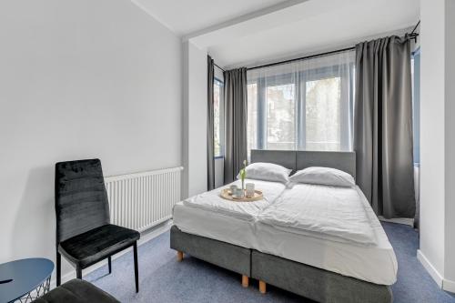 a bedroom with a bed and a chair and a table at Przystanek Sopot Plaża in Sopot