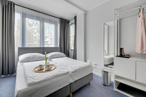 a bedroom with a bed with a tray of flowers on it at Przystanek Sopot Plaża in Sopot