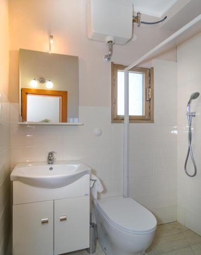 a white bathroom with a sink and a toilet at Villa Grazia in Viareggio