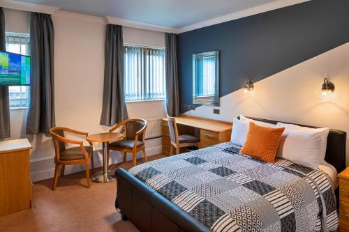 a hotel room with a bed and a desk at Weetwood Hall Estate in Leeds