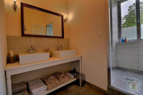 a bathroom with two sinks and a mirror at Les voisins de l'illet in Ercé-près-Liffré