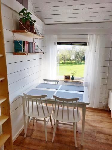 a tiny house with a table and two chairs at Lillstugan - Centralt och havsnära i lugnt villområde in Falkenberg