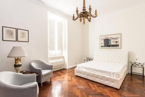 sypialnia z łóżkiem, krzesłem i żyrandolem w obiekcie Vatican Large Comfortable Apartment w Rzymie