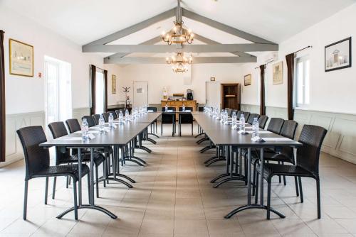 a large dining room with a long table and chairs at Best Western Plus Le Canard sur le Toit in Colomiers