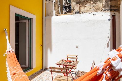 eine Terrasse mit 2 Hängematten, einem Tisch und einer Bank in der Unterkunft Lisbon Chillout Apartments in Lissabon