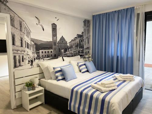 a bedroom with a large bed with blue curtains at Family Resort Urania in Baška Voda