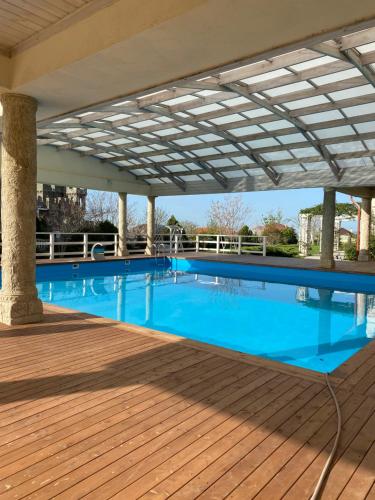 una gran piscina de agua azul en una terraza de madera en Hotel Alexandria, en Anapa