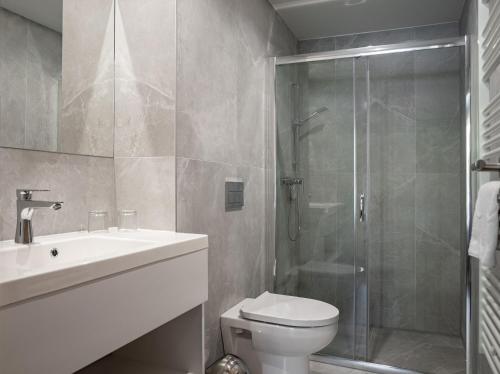 a bathroom with a shower and a toilet and a sink at R31 Residence in Sárvár