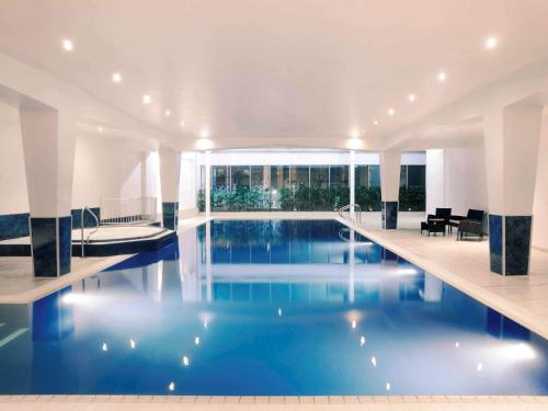 a large swimming pool in a hotel room at Mercure Cardiff Holland House Hotel & Spa in Cardiff