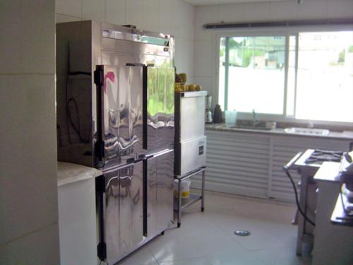 a kitchen with a large stainless steel refrigerator at Hotel Flamboyant in Itaquaquecetuba