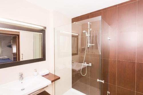 a bathroom with a shower and a sink and a mirror at HomeHolidaysRentals Amaral in Pineda de Mar
