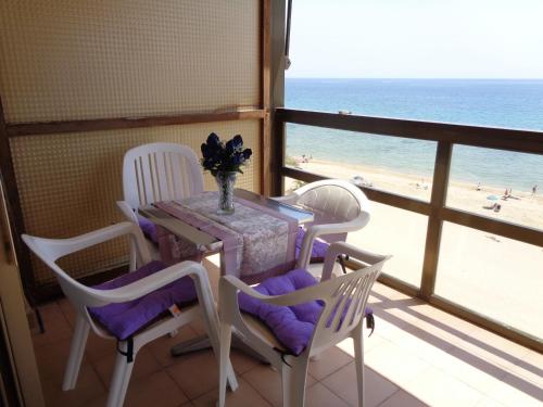 a table and chairs in a room with a view of the beach at Edificio Calpemar in Calpe