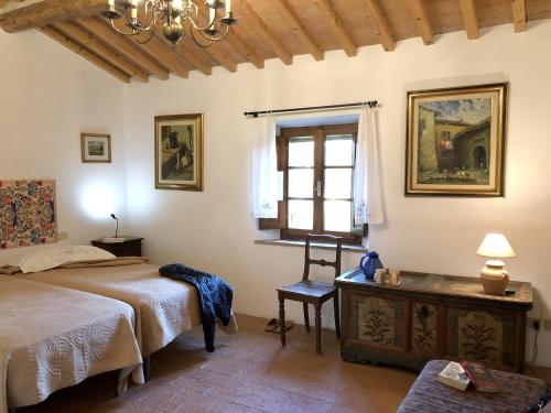 a bedroom with two beds and a window at Podere Morena with sea view, private terrace by ToscanaTour Greg in Guardistallo