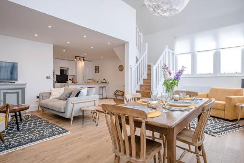 a dining room and living room with a table and chairs at One The Old School, Leiston in Leiston