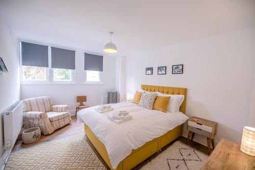 a bedroom with a large bed and a chair at One The Old School, Leiston in Leiston