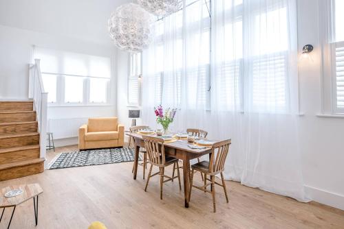 a dining room with a wooden table and chairs at One The Old School, Leiston in Leiston