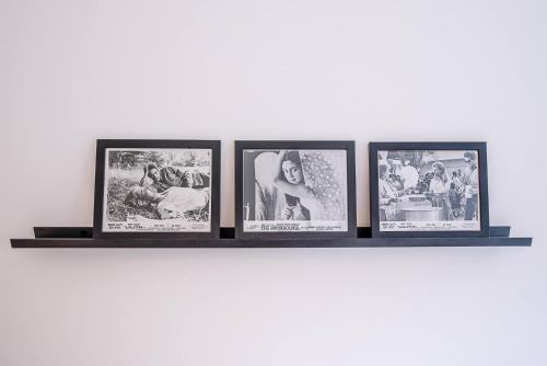 a shelf with four framed pictures on a wall at One The Old School, Leiston in Leiston