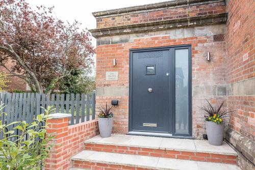 a black door on the side of a brick building at One The Old School, Leiston in Leiston