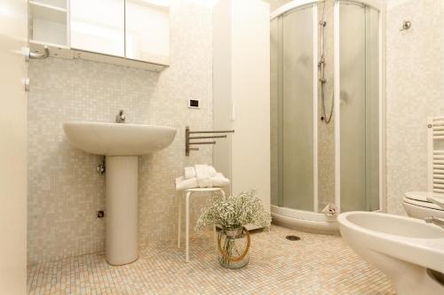 ein Bad mit einem Waschbecken, einer Dusche und einem WC in der Unterkunft Yourbanflat Porta Altinate in Padua
