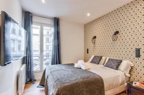 une chambre avec un grand lit et une fenêtre dans l'établissement 104 - Urban Opera Lafayette, à Paris
