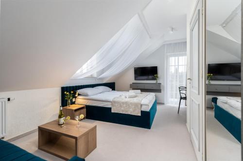 a bedroom with a bed and a tv and a couch at Zamkowe Apartamenty in Sandomierz