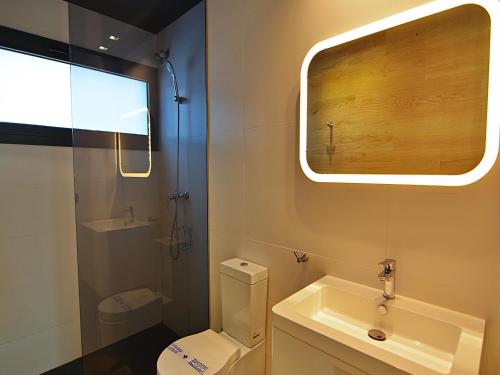 a bathroom with a toilet and a sink and a window at Villa Blanca in L'Escala