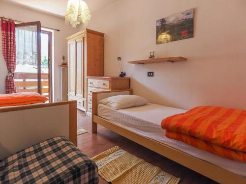 een slaapkamer met 2 bedden en een raam bij Casa Tubertini- Poletti in Moena