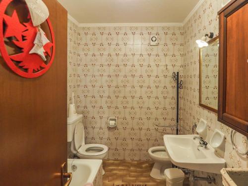 a bathroom with two toilets and a sink at Casa Tubertini- Poletti in Moena