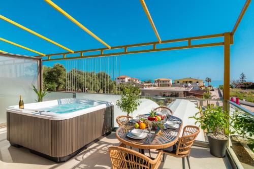 a patio with a table and chairs and a hot tub at Aphrodite Studios & Suites - 140m from the beach, by ZanteWize in Alykes