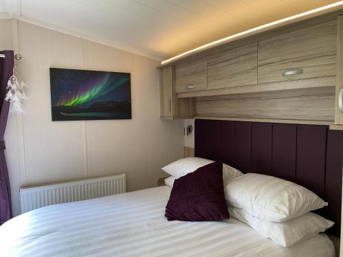 Voodi või voodid majutusasutuse Auroras Dream Lodge - Hoburne Cotswolds Holiday Park toas