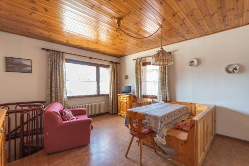 a living room with a table and a chair at Casa Carnevali in Pozza di Fassa