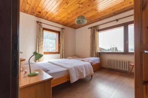 ein Schlafzimmer mit einem Bett und einem großen Fenster in der Unterkunft Casa Carnevali in Pozza di Fassa