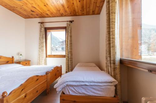 a bedroom with two beds and a window at Casa Carnevali in Pozza di Fassa