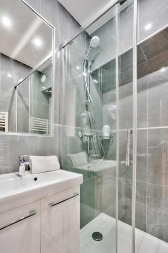 une salle de bain avec une douche en verre et un lavabo dans l'établissement 106 - Urban Luxury Opera Gustav Klimt, à Paris