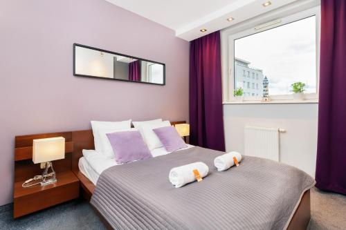 a bedroom with a bed with two towels on it at City and Sea View Apartments by Renters in Gdańsk