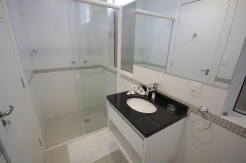 a white bathroom with a sink and a shower at Hotel Emacite Flex in Mafra