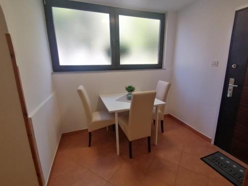 a dining room with a table and chairs and a window at Apartments Pepe in Novigrad Istria