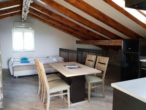 a dining room with a table and chairs and a bed at Apartments Villa Irena in Koper