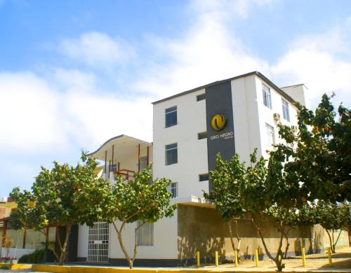 a white building with a clock on the side of it at Hotel Oro Negro in Talara