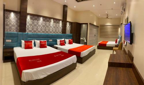 a hotel room with two beds and a television at Hotel Blossom Inn in Amritsar