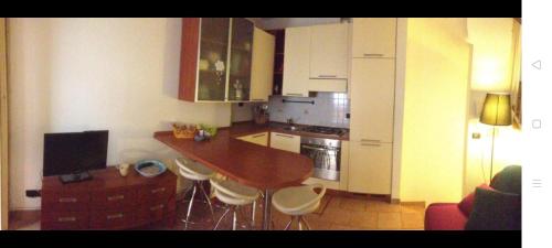 a kitchen with a wooden table and white cabinets at Appartamento il pozzo in Lecco