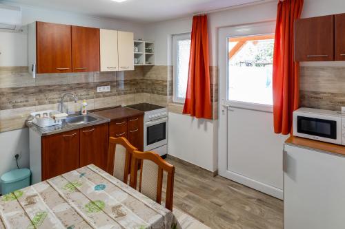 uma pequena cozinha com uma mesa e um lavatório em Lili Apartman em Harkány