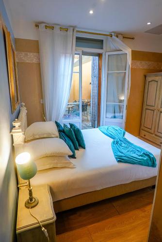 a bedroom with a large bed with a window at Hotel Relais Du Postillon in Antibes