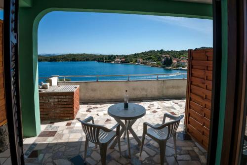 a patio with a table and chairs and a view of a lake at Picić Guesthouse in Luka