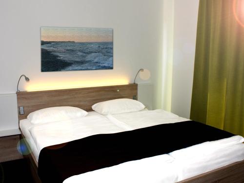 - un lit dans une chambre dotée d'un rideau vert dans l'établissement Premium Haus, à Damp