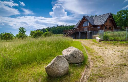 a house with two rocks in front of it at Ranch Jestřebice in Heřmaničky