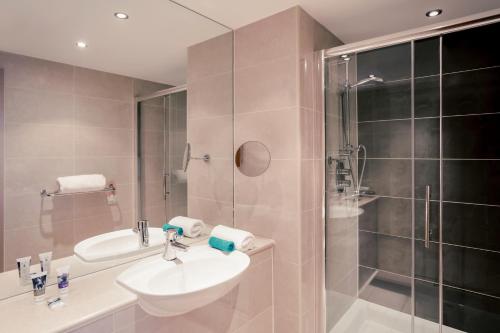 a bathroom with a shower, sink, and tub at Mercure Bristol Holland House in Bristol