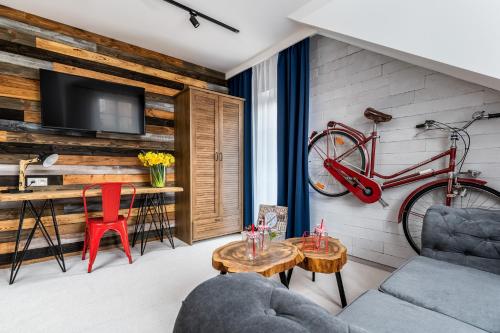 a living room with a red bike hanging on a wall at Zamkowe Apartamenty in Sandomierz