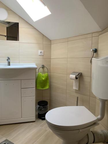 a bathroom with a white toilet and a sink at Levendulakert Siófok Apartmanház in Siófok
