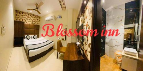 a bedroom with a bed and a desk in a room at Hotel Blossom Inn in Amritsar